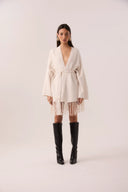 Capa de tricô off-white com franjas e faixa de amarrar