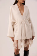 Capa de tricô off-white com franjas na barra e faixa de amarrar