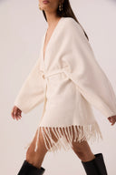 Capa de tricô off-white com franjas e faixa de amarrar