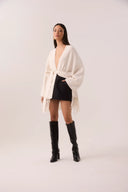 Capa de tricô off-white com franjas e faixa de amarrar
