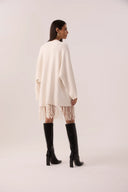 Capa de tricô off-white com franjas e faixa de amarrar