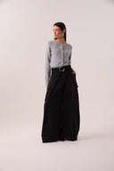 Calça maxi pantalona preta em sarja com pernas muito amplas, cinto e bolsos